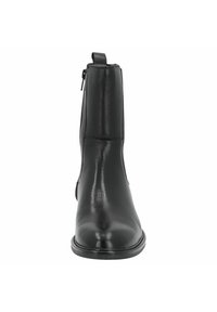 Bota de tobillo de cuero negro con un acabado suave, puntera redondeada, cremallera lateral y suela de perfil bajo, diseñada para una silueta elegante.