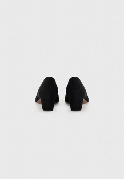 Μαύρα σουέντ γυναικεία παπούτσια με ψηλό τακούνι, στρογγυλεμένη μύτη και χοντρό τακούνι, με λεία υφή και μινιμαλιστικό σχεδιασμό χωρίς ορατές διακοσμήσεις.