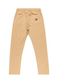 Beżowe spodnie wykonane z tkaniny plecionej, z elastycznym paskiem w talii, dwoma tylnymi kieszeniami i małą metką z logo na prawej kieszeni.