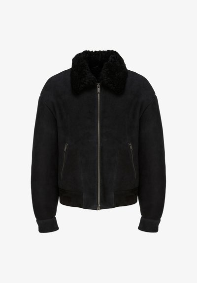 Veste bomber en suède noir avec col en peau lainée, fermeture éclair avant et poches latérales zippées.