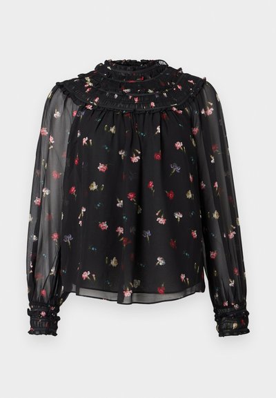 Camicia nera trasparente con colletto arricciato, maniche lunghe e polsini elastici. Presenta una stampa floreale in tonalità di rosso, rosa e blu.