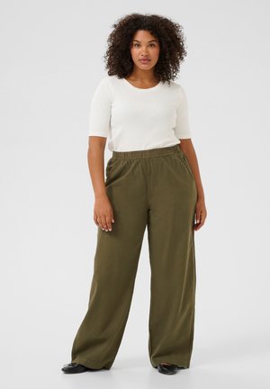 Pantalons larges en lin vert olive léger avec une taille élastique, associés à un haut blanc à manches courtes texturé.