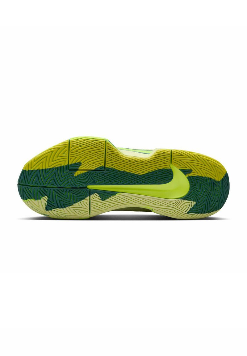 Semelle de sneaker Nike en jaune et vert vif. Présente un motif de traction ondulé avec un logo Nike lisse. Matériau en caoutchouc durable.