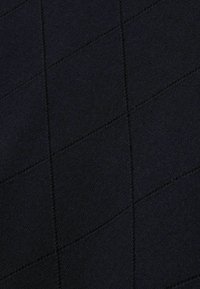 Svart textil med ett kviltat mönster som har diagonala linjer och subtil textur. Tyget verkar mjukt och är jämnt stickat.