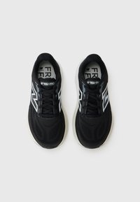 Pair of black New Balance running shoes with white logo and cushioned soles, viewed from above on a plain white background.