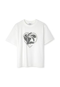 Camiseta de algodón blanca con un diseño de corazón negro y patrones botánicos. Mangas cortas y un corte relajado. Estilo de cuello redondo.