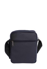 Bolso cruzado compacto de color azul marino con bolsillo frontal con cremallera y correa de hombro negra ajustable, presentado sobre un fondo blanco.