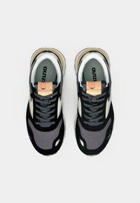 Black and grey athletic shoes with a mesh and synthetic upper, featuring a cream accent, textured detailing, and a rubber sole.