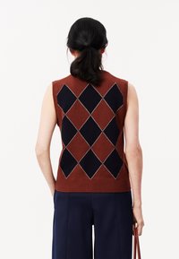 Maglione senza maniche in maglia con motivo argyle marrone e blu navy, con dettagli bianchi, caratterizzato da un orlo a coste e una vestibilità rilassata. Vista posteriore mostrata.