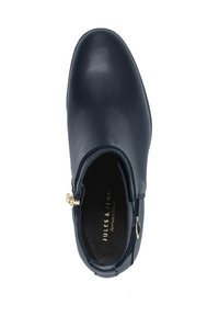 Marineblaue Lederknöchelstiefel mit glatter Oberfläche, abgerundeter Zehenform und goldenem Reißverschlussdetail an der Seite. Weiche Innenausstattung sichtbar.