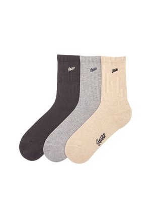 Drei Paar gerippte Socken in Dunkelgrau, Hellgrau und Beige. Jede Socke hat ein kleines schwarzes Logo nahe der Oberseite.