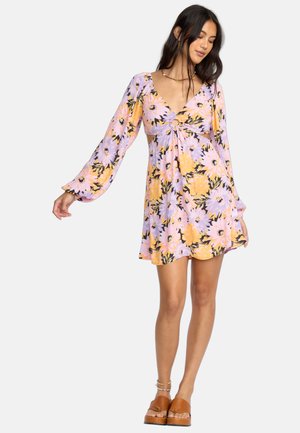Robe florale avec un motif lavande et jaune, un décolleté en V profond, des manches longues, et une taille cintrée avec un détail découpé.