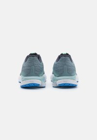 Des chaussures de course avec une tige en mesh gris et des accents bleus, une semelle intermédiaire blanche rembourrée et une semelle extérieure en caoutchouc texturé pour une adhérence optimale.