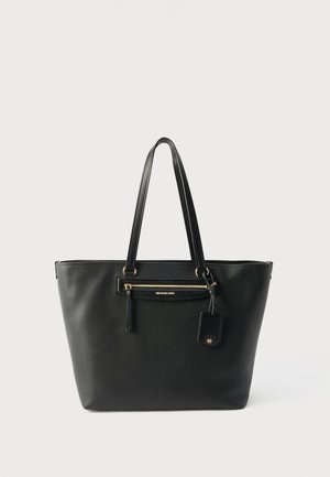 Black leather tote bag with double shoulder straps, front zip pocket, and hanging tag with gold-tone hardware details.