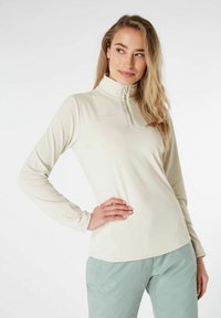 Vaaleanbeige pitkähihaisen vetoketjulla varustetun paidan valmistusmateriaali on pehmeää. Paidassa on pystykaulus ja slim fit -muotoilu, joka sopii ulkoiluun.