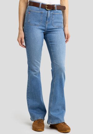Jeans de mezclilla de corte acampanado en azul claro con una cintura alta. Cuenta con un cinturón marrón, cinco bolsillos y un ligero desgaste en la textura de la tela.