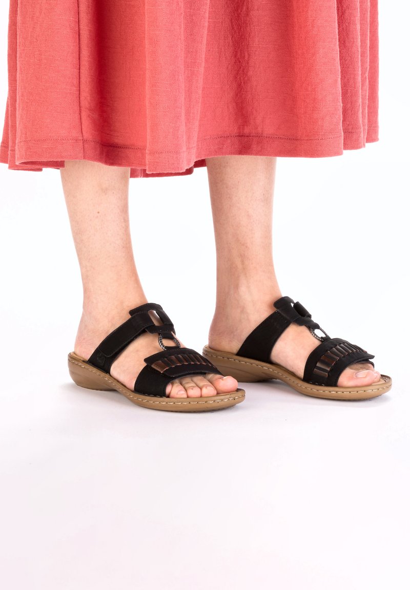 Sandales en suède noir avec des sangles réglables, design ouvert à l'avant, et des embellissements texturés sur le dessus, complétant une semelle beige.