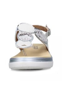 Sandali argentati con una finitura liscia e lucida, design floreale ritagliato, cinturino alla caviglia regolabile e una soletta beige imbottita.