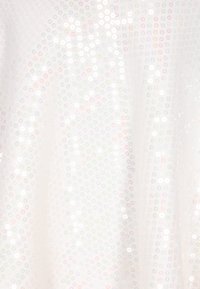 Tessuto bianco coperto di piccoli paillettes colorate a forma circolare. Le paillettes riflettono la luce con una texture lucida, creando una superficie texturizzata.