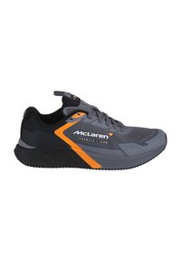 Gray athletic shoe with black accents and an orange stripe. Features a mesh upper, laces, and a textured rubber sole. McLaren branding visible.