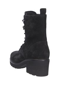 Botines de ante negro con un tacón grueso, cordones en la parte frontal y herrajes decorativos metálicos. Acabado texturizado y una pestaña en la parte trasera.