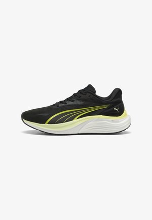 Zapatilla de correr Puma en negro y amarillo neón con suela acolchada blanca, parte superior de malla y logo de Puma en el talón, vista lateral sobre fondo blanco.