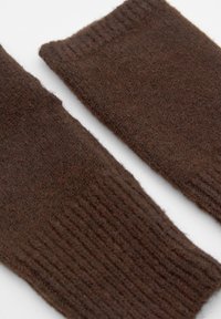 Braune gestrickte Armschoner mit einer weichen Textur, mit gerippten Kanten und einem einfachen, länglichen Design.