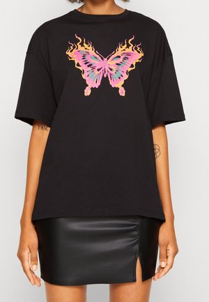 Black oversized T-shirt with a large pink and orange flaming butterfly graphic in the center, paired with a black leather skirt with a front slit.