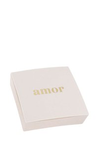 Kvadratisk, blekrosa låda med en glänsande yta. Centrerad guldtext med texten "amor." Kanterna är något rundade, minimalistisk design utan ytterligare mönster.