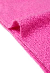Tessuto di lana rosa con una texture morbida, caratterizzato da un pregiato motivo a maglia, piegato per mostrare un bordo liscio e una ricca profondità di colore.
