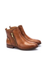 Botas de tobillo de cuero marrón con un zipper dorado lateral, punta redondeada y tacón de madera apilado. Textura suave y diseño minimalista.