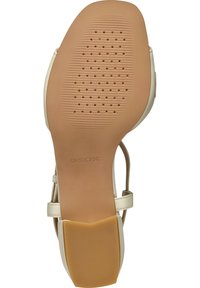 Beige sandal med en gummisula som har en slät textur och mönstrade spår, samt en liten klack för stabilitet.