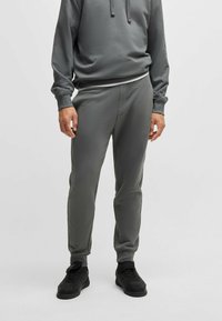 Grijze sweatpants en bijpassende hoodie, gemaakt van zacht materiaal. Slim fit ontwerp met ribbels aan de manchetten, voorzien van een verstelbare capuchon met koord.