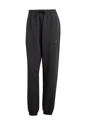 Mustad mustadrõngadega mustad dressipüksid, elastsete soonikutega, küljetaskute ja diskreetse logoga, valmistatud pehmest kangast, millel on sile tekstuur.