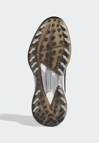 Shoe sole with clear and black sections, featuring white arrow-shaped and circular traction studs for enhanced grip.
