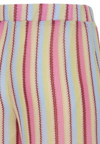 Lähivaade kampsuni vöökohal olevast kudumisest, millel on vertikaalsed triibud pastelselt roosas, kollases, sinises ja burgundia värvis.