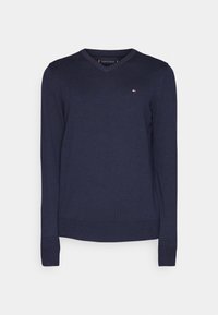 Pull bleu marine à col en V, confectionné dans un matériau doux, avec des manches longues et un petit logo sur la poitrine. Texture lisse, coupe ajustée.