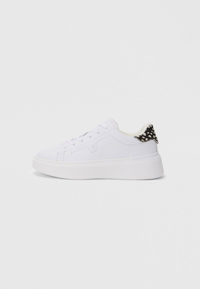 Adidași albi cu un superior din piele netedă, vârf rotund, talpă plată din cauciuc alb și un accent cu buline negre și albe pe toc.