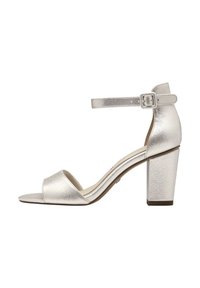 Des sandales à talons métalliques argentés présentent une large bride avant, une bride autour de la cheville avec boucle et un talon épais. Texture lisse, design ouvert à l'avant.