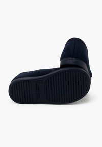 Juodos suede bateliai su apvaliu noseliu, žemu kulnu, raštuotu guminiu padu ir siuvimo detalėmis, matomomis siūlės vietose.
