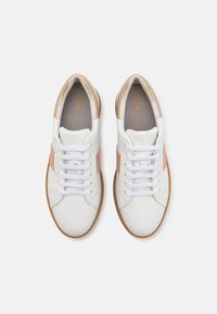 Hvite og lys rosa sneakers laget av lær og tekstilmaterialer, rund tå og kontrasterende tan gummisåle; har hvite lisser og merke.