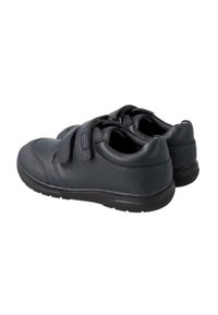 Zapatos de cuero negro con dos correas de Velcro, punta redondeada y suela texturizada para un mejor agarre. Su diseño elegante enfatiza la funcionalidad práctica.