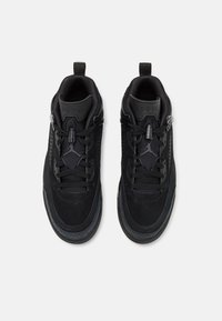 Black athletic shoes featuring a mix of suede and mesh materials, a streamlined design, textured detailing, and contrasting accents.