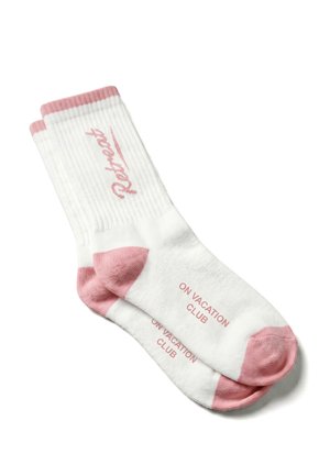 White socks with pink toes, heels, and cuffs, featuring the words "Rotator" on the leg and "ON VACATION CLUB" on the sole in pink text.
