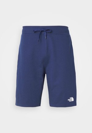 Bermudas de algodón azul marino con cintura elástica y cordón. Presenta un logo blanco en la esquina inferior derecha. Textura suave.