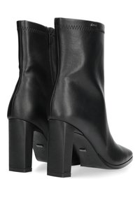 Czarne skórzane botki za kostkę o gładkiej fakturze, z zaostrzonym noskiem i kwadratowym wysokim obcasem. Posiadają boczny zamek błyskawiczny i minimalistyczne przeszycia.