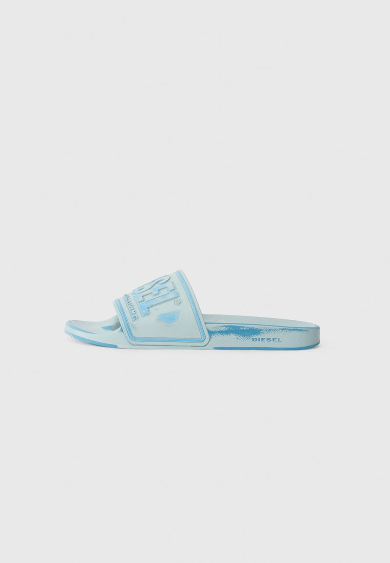 Light blue slide sandal with a textured strap featuring an embossed logo, a flat sole, and smooth rubber material.