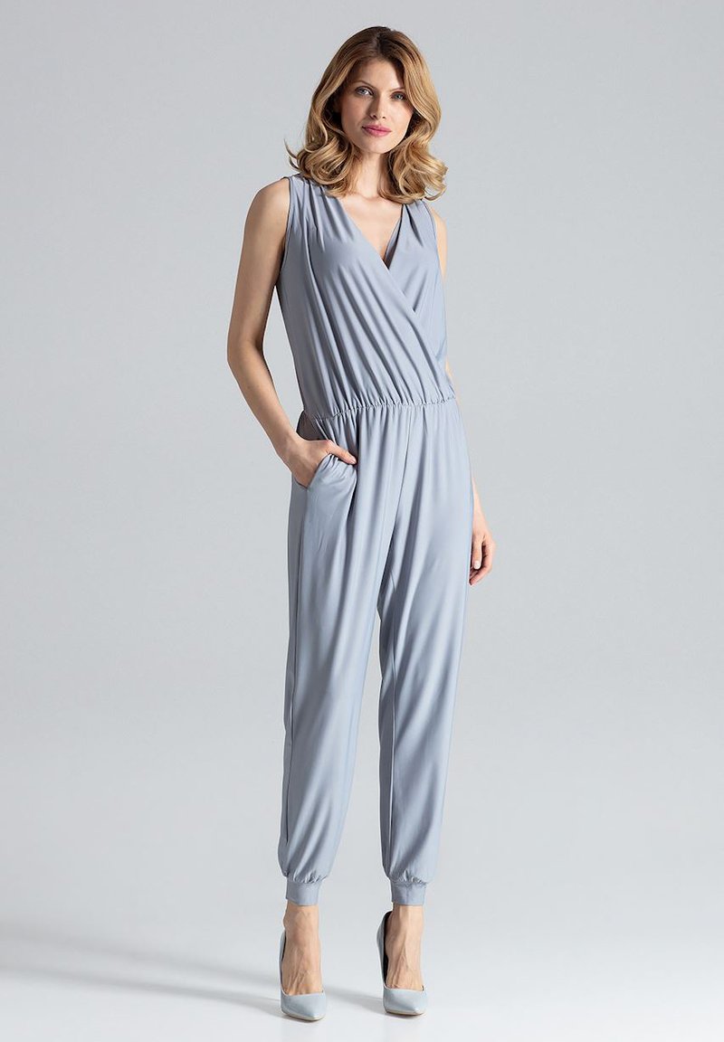 Lichtblauwe jumpsuit met een V-halslijn, elastische taille en zakken. Gemaakt van een gladde stof, met taps toelopende benen en een relaxte pasvorm.