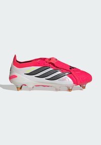 Κόκκινο και άσπρο ποδοσφαιρικό παπούτσι Adidas Predator με μαύρες ρίγες, σόλα με τάπες και κορδόνια καλυμμένα από ροζ επικάλυψη.
