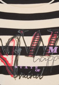 Schwarz-weiß gestreifter Strickoberteil mit mehrfarbigem grafischem Text und Verzierungen. Das Design umfasst unterschiedliche Liniendicken und Texturen.